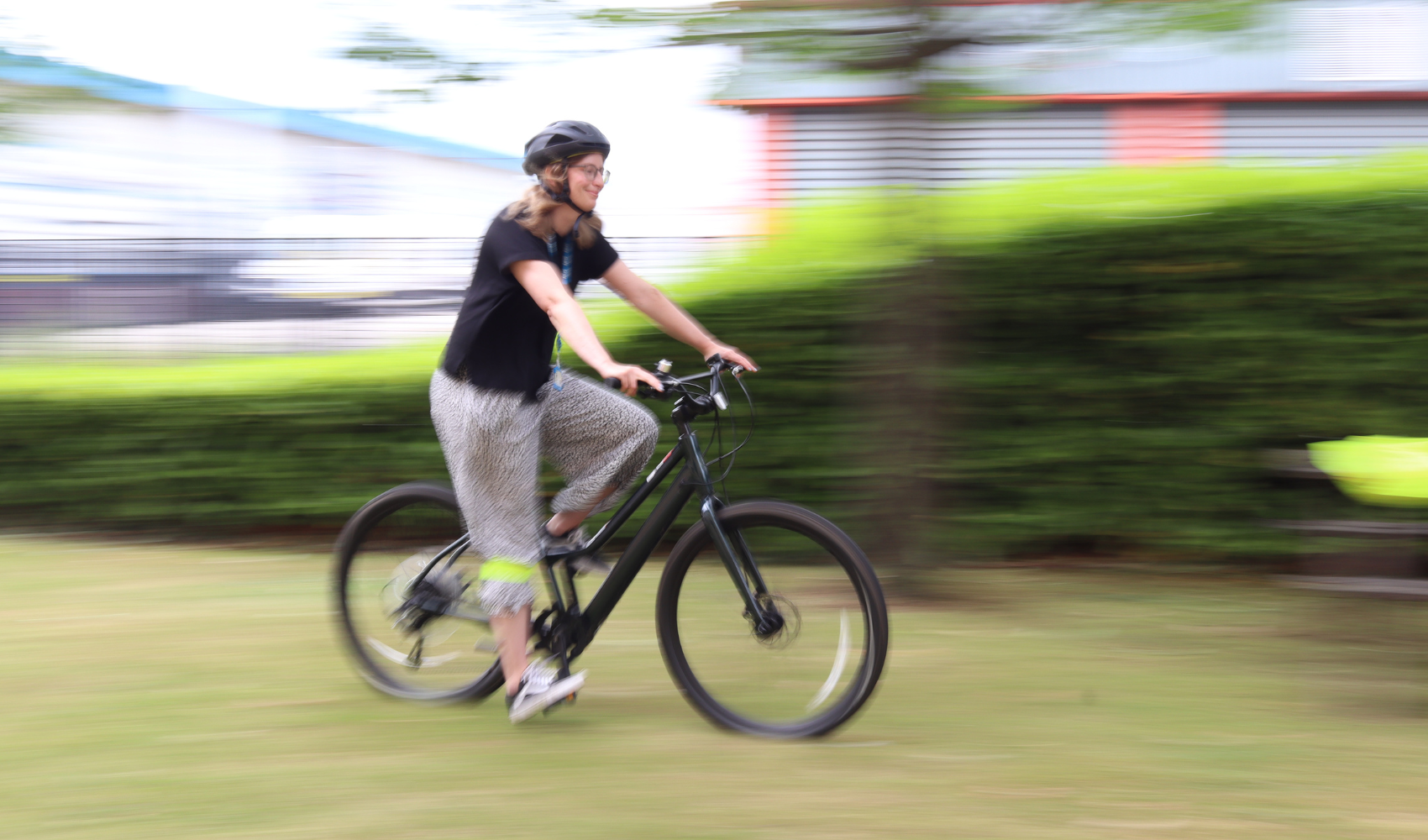 Cyclist on an e-bike moving blurrily from left to right
