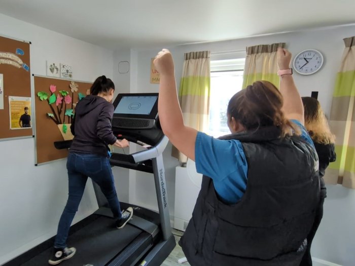 Person cheering on while watching another person on a treadmill
