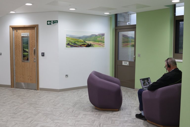 Man sits on a chair in a corridor